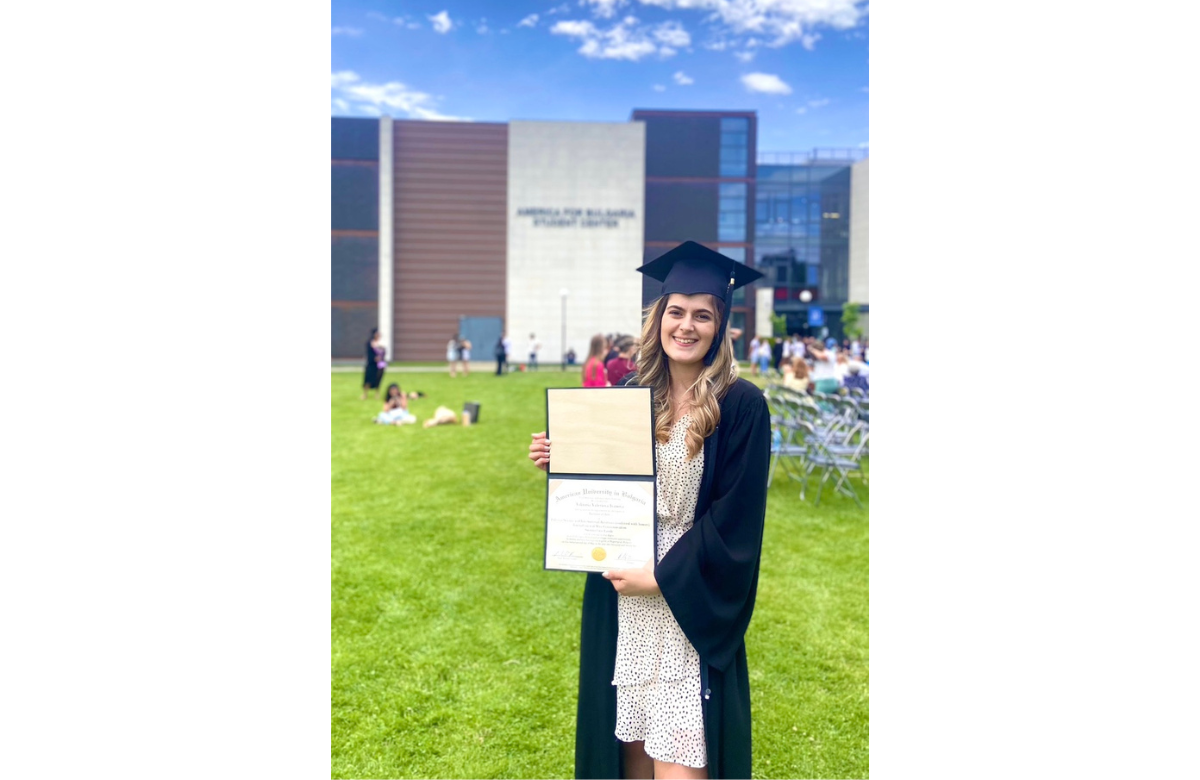 Viktoria Ivanova posing with her AUBG diploma